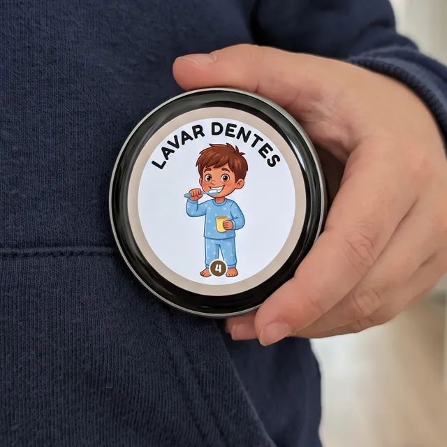 E-Badge redondo com o cartão Lavar dentes, seguro junto à camisola de uma criança