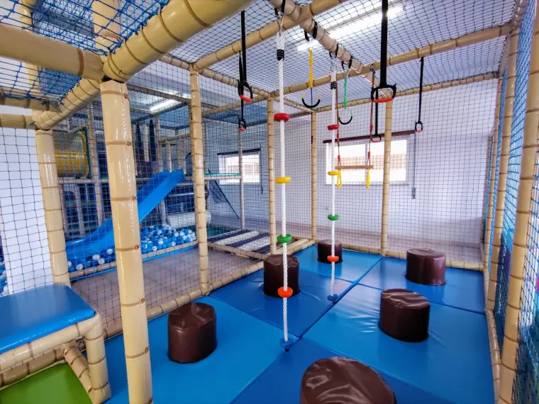 Estrutura de obstáculos com argolas, cordas e escorrega para a piscina de bolas