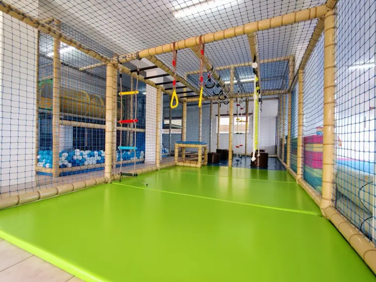 Percurso suspenso com argolas e cordas sobre chão verde